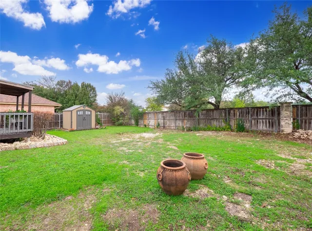 a view of a house with backyard and a tree