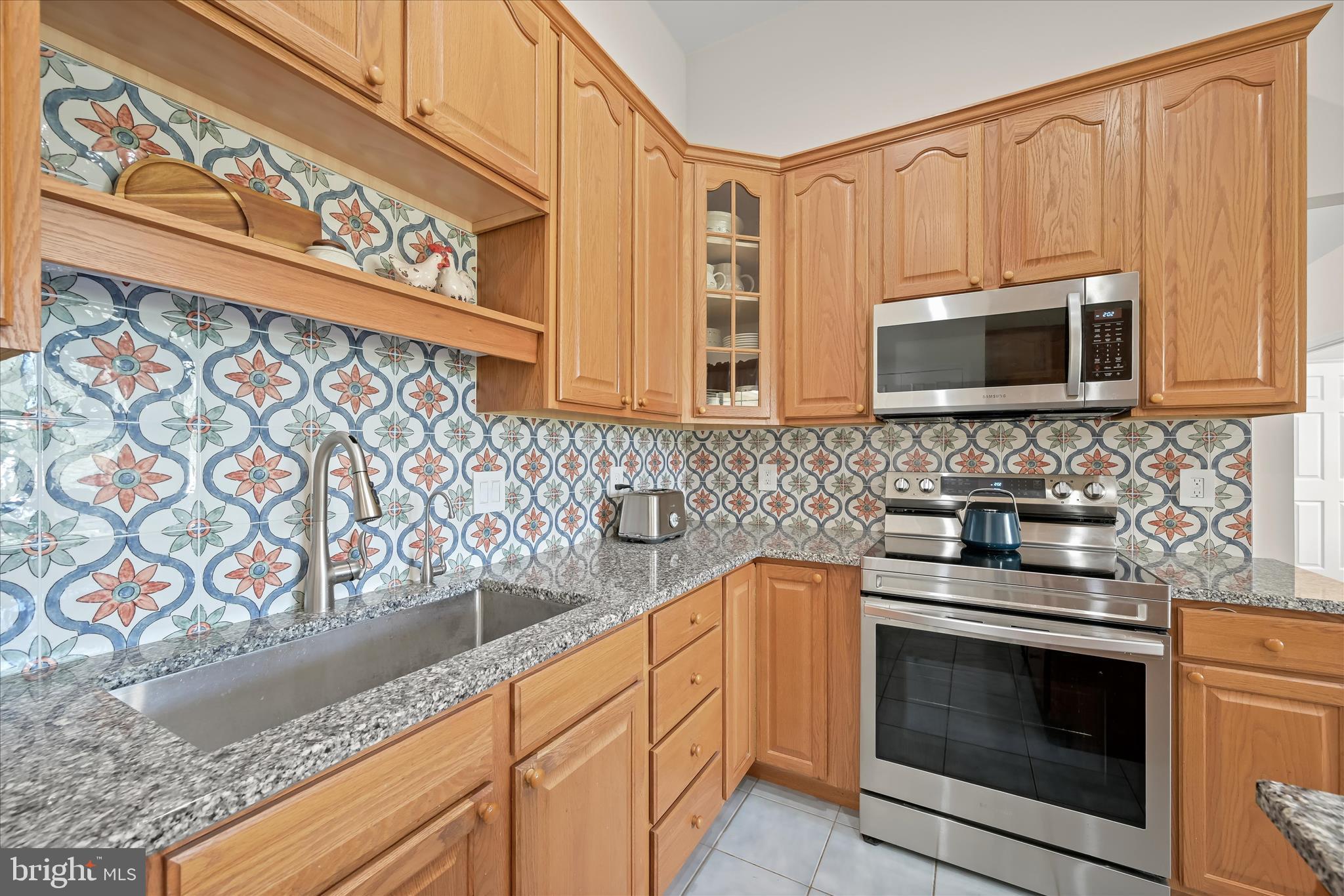 6735 Mink Hollow Road Highland, MD 20777 - Photo 17 of 58 a kitchen with granite countertop white cabinets stainless steel appliances and wooden floor