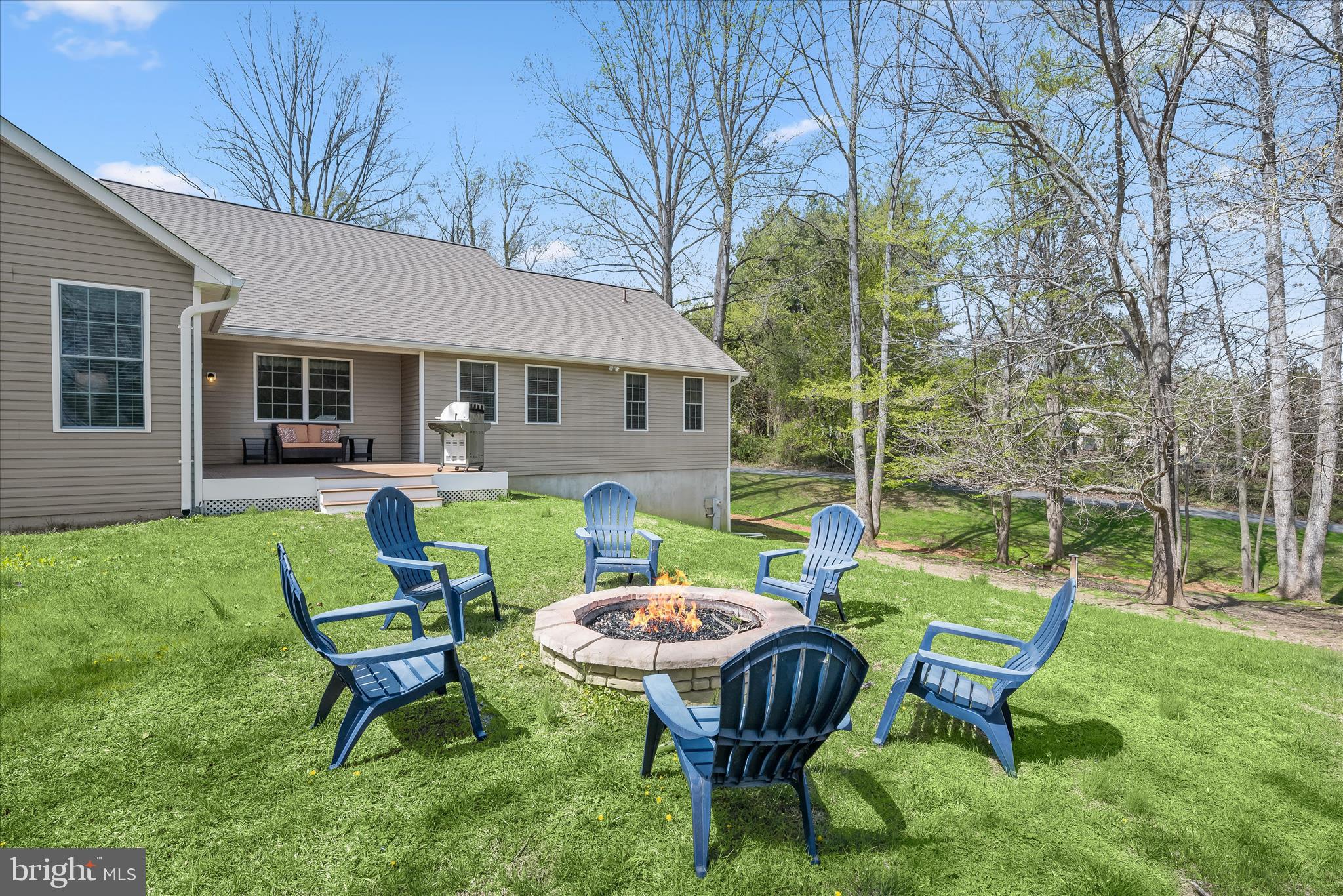 6735 Mink Hollow Road Highland, MD 20777 - Photo 48 of 58 a view of a backyard with table and chairs with a fire pit and a large tree