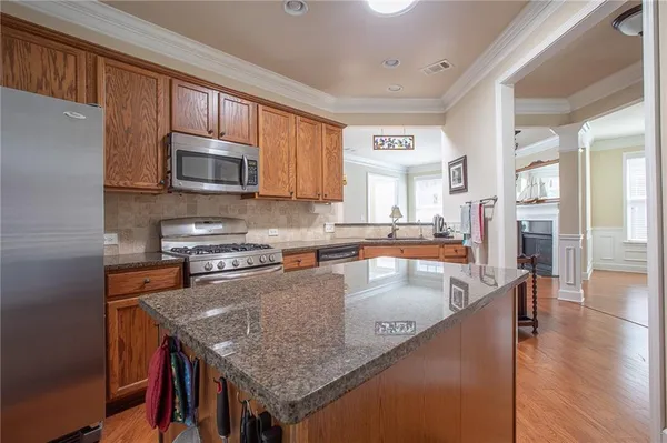 a kitchen with stainless steel appliances granite countertop a stove a sink and a microwave