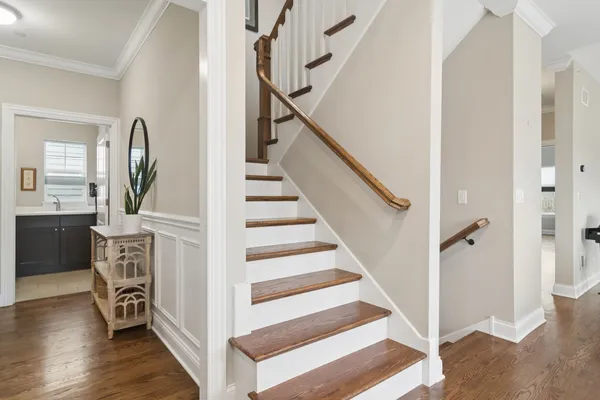 a view of front door with hallway and wooden floor