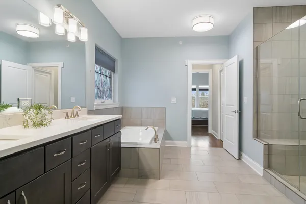a spacious bathroom with a granite countertop sink a mirror and a shower