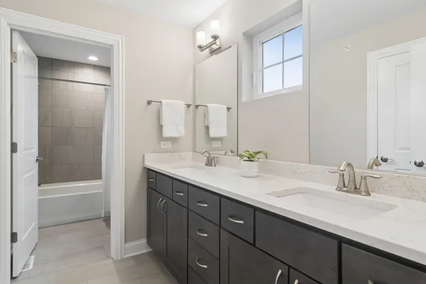 a bathroom with a sink double vanity granite tub and a mirror