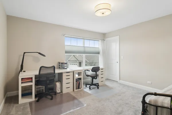 a view of a workspace with furniture and a window