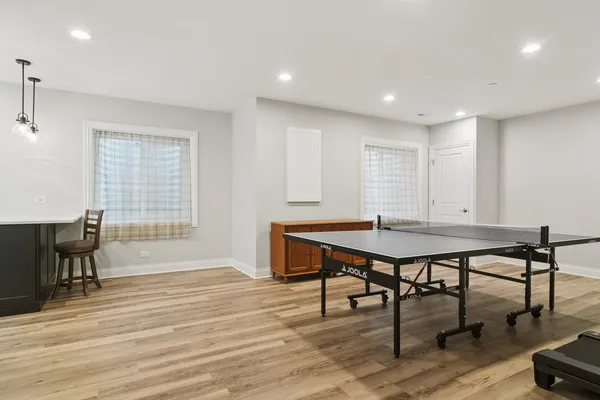 a room with furniture pool table wooden floor and windows