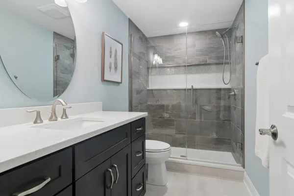 a bathroom with a sink a toilet and shower