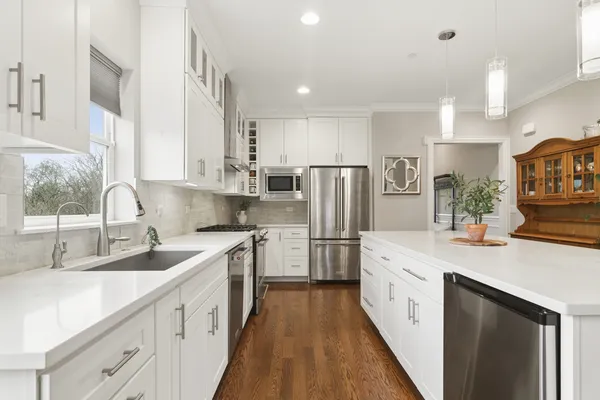 a kitchen with white cabinets sink and refrigerator