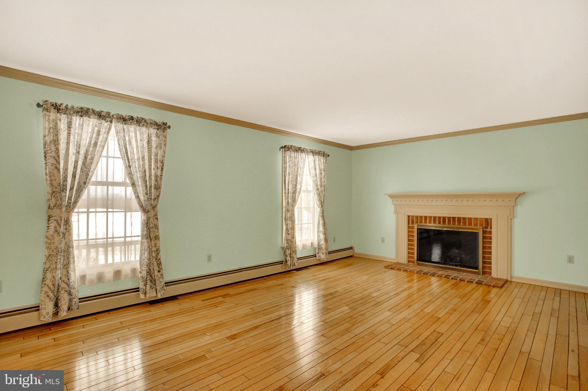 202 South Ridge Road Boiling Springs, PA 17007 - Photo 7 of 36 an empty room with wooden floor fireplace and windows