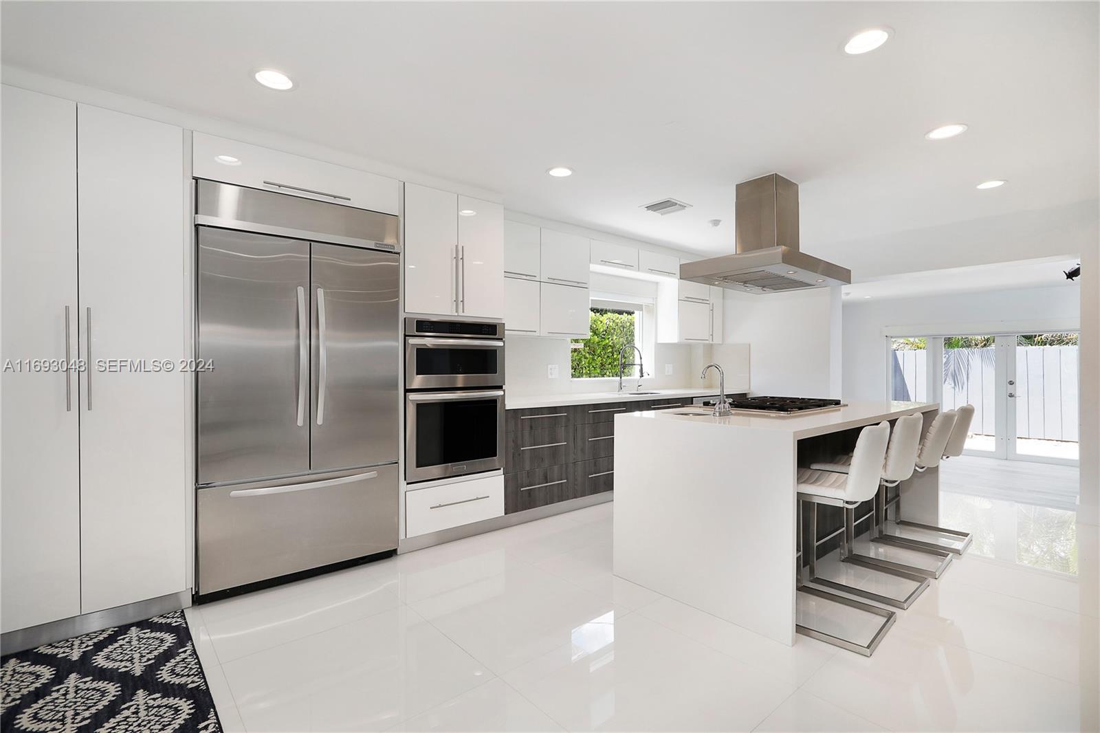 9611 Southwest 59th Terrace Miami, FL 33173 - Photo 12 of 32 a kitchen with stainless steel appliances kitchen island granite countertop a refrigerator and a stove top oven