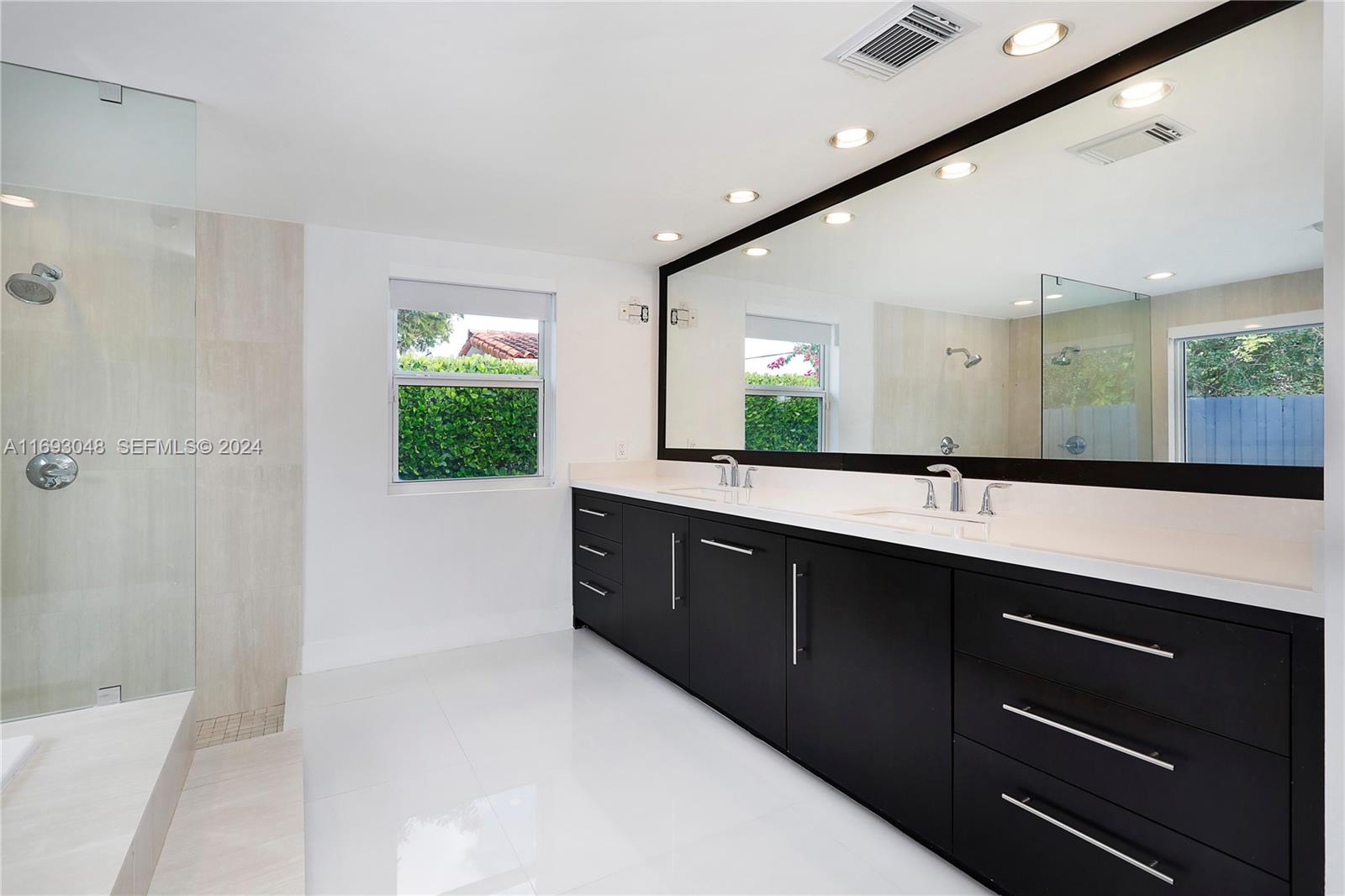 9611 Southwest 59th Terrace Miami, FL 33173 - Photo 17 of 32 a spacious bathroom with a double vanity sink a large mirror and shower