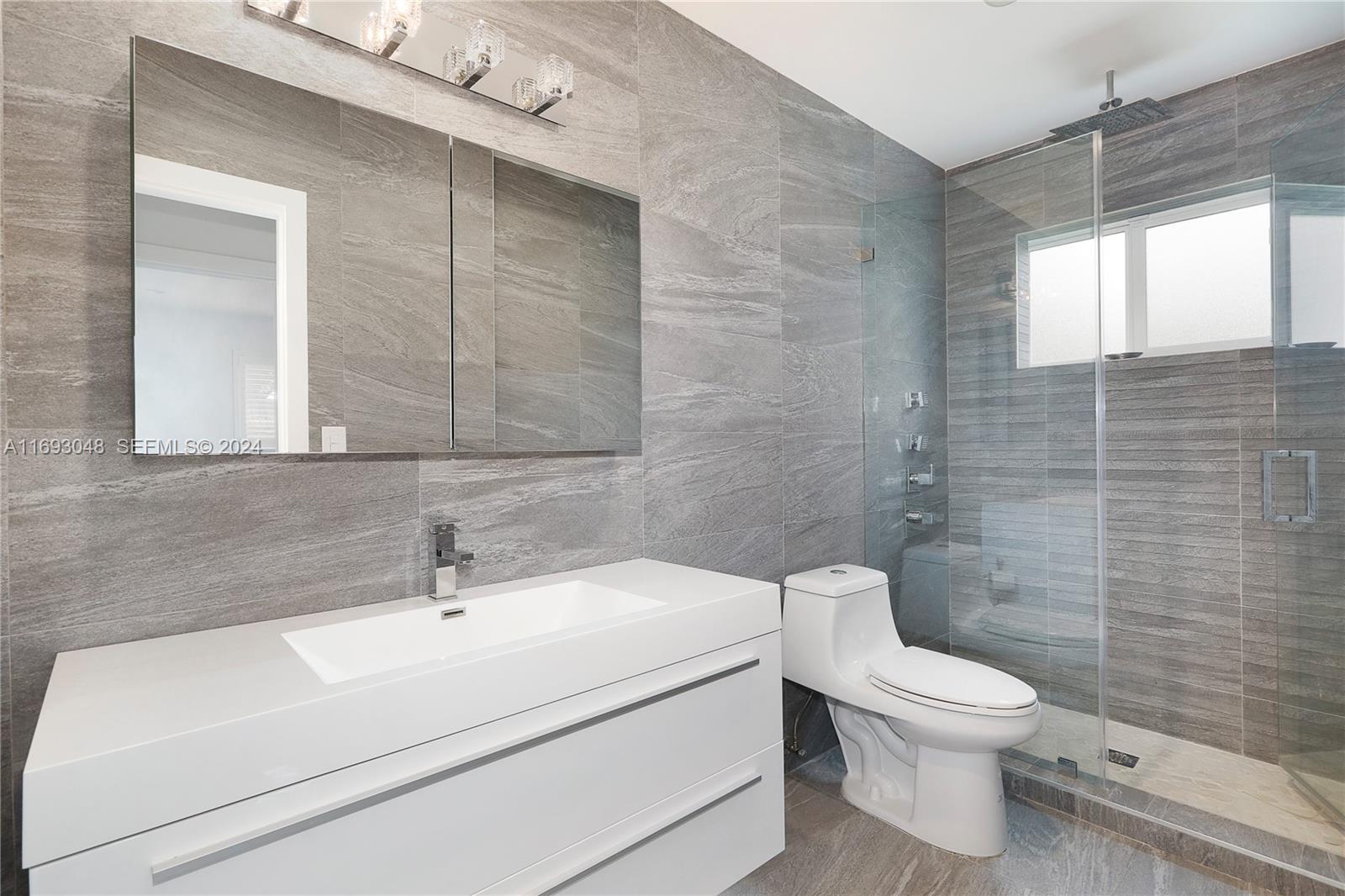 9611 Southwest 59th Terrace Miami, FL 33173 - Photo 22 of 32 a white toilet sitting next to a bathroom sink