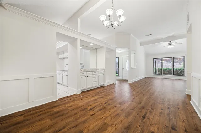 a kitchen with granite countertop white cabinets and white appliances