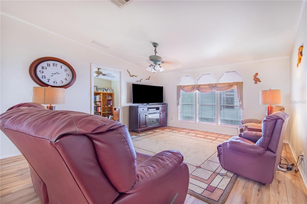 332 Fairway Boulevard Frostproof, FL 33843 - Photo 14 of 56 a living room with furniture a flat screen tv and a large window