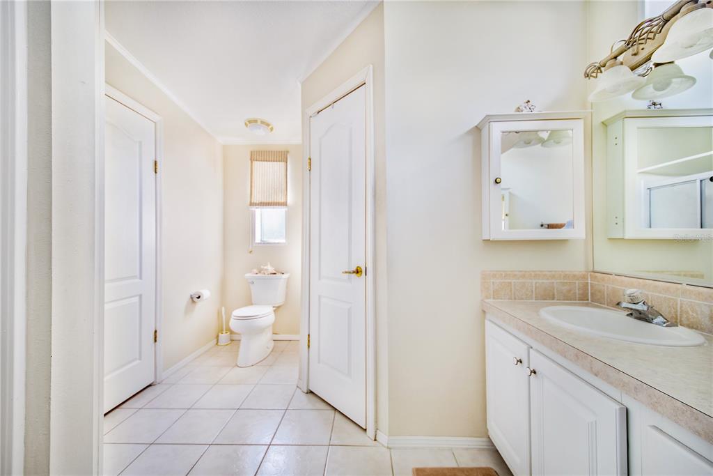 332 Fairway Boulevard Frostproof, FL 33843 - Photo 23 of 56 a spacious bathroom with a granite countertop sink toilet and a mirror