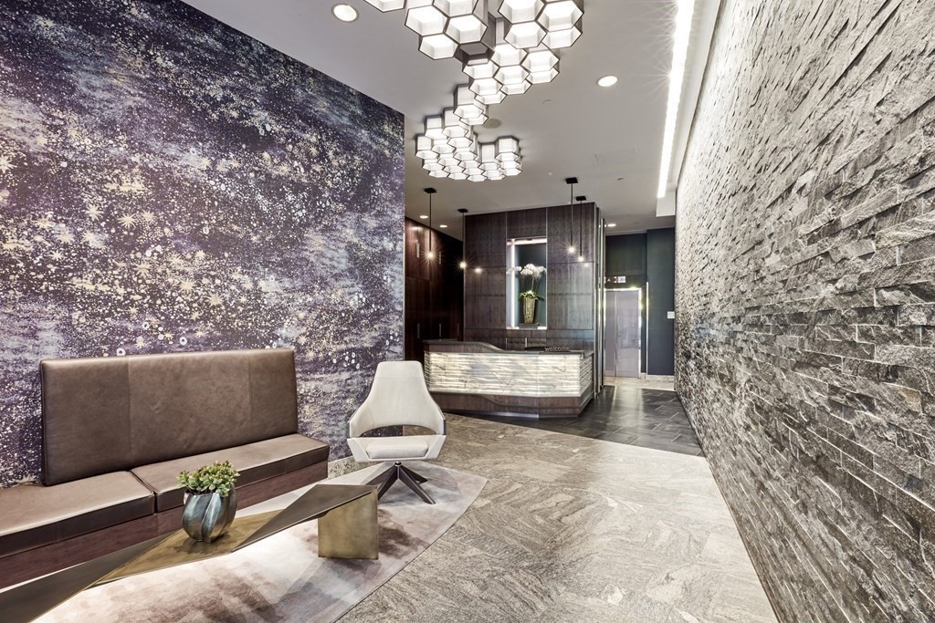 110 Stuart Street, Unit 26F Boston, MA 02116 - Photo 19 of 24 a living room with couches a fireplace and a chandelier