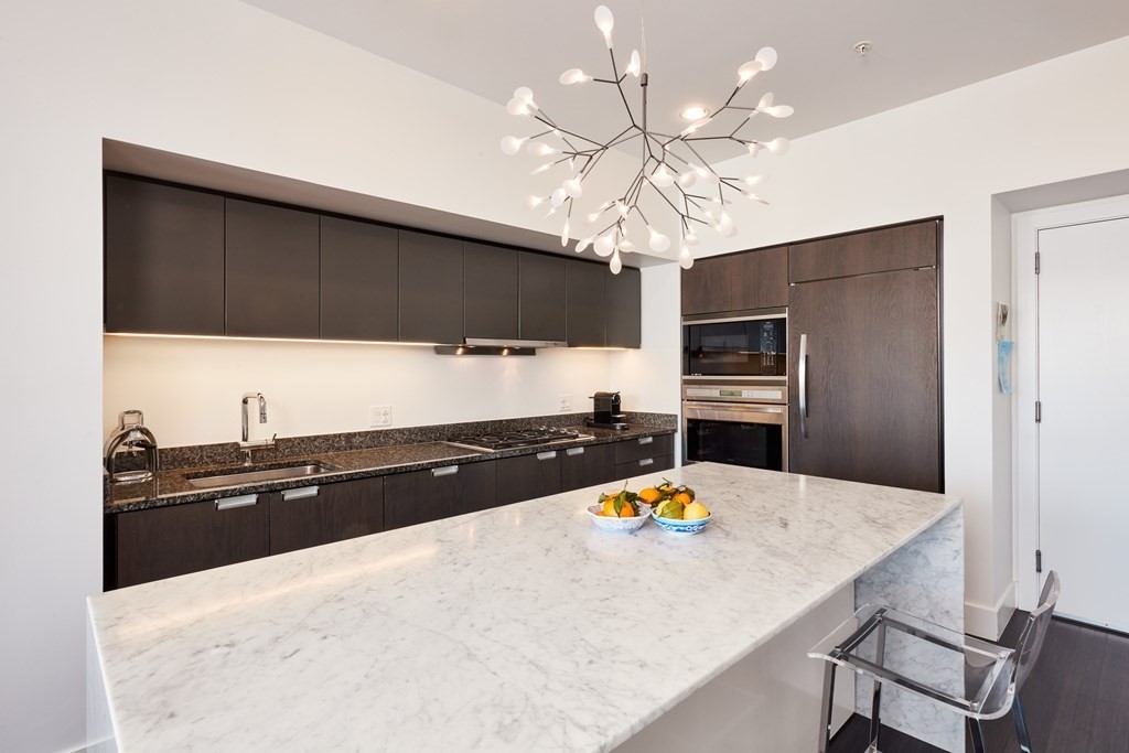 110 Stuart Street, Unit 26F Boston, MA 02116 - Photo 7 of 24 a kitchen with stainless steel appliances a sink and refrigerator