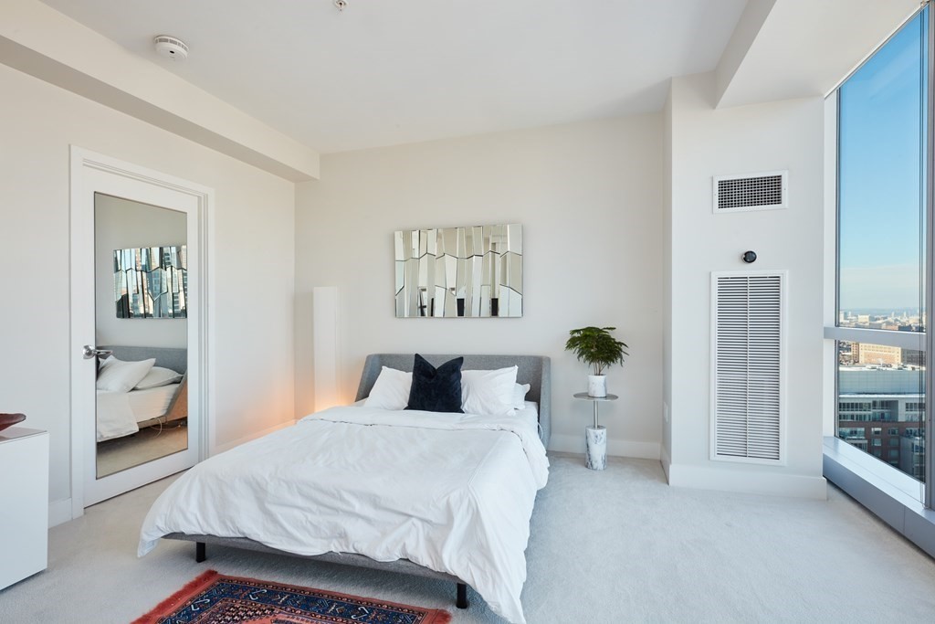 110 Stuart Street, Unit 26F Boston, MA 02116 - Photo 9 of 24 a bedroom with a white bed and white walls