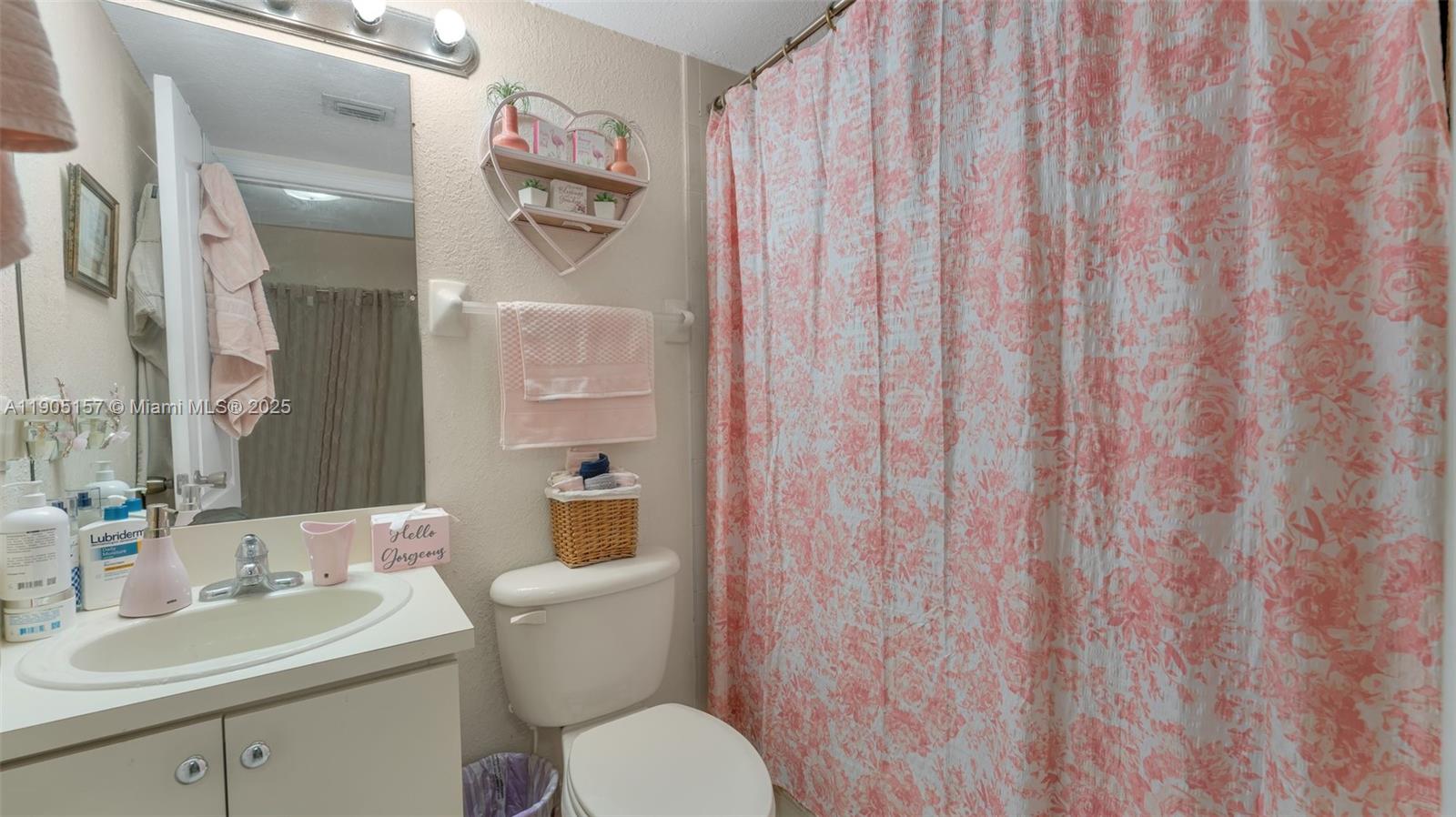 2993 West 80th Street, Unit 29 Hialeah, FL 33018 - Photo 15 of 21 a bathroom with a toilet a sink and a mirror