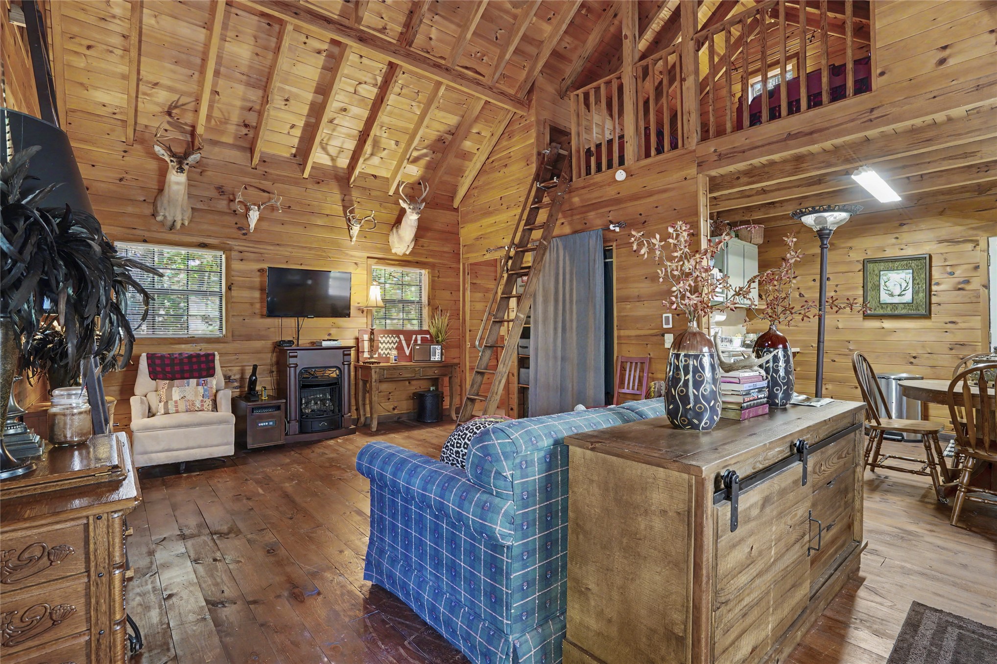 46420 South 590 Road Jay, OK 74346 - Photo 5 of 63 Vaulted wood-paneled ceiling with exposed beams, wood-plank flooring, and a built-in electric fireplace