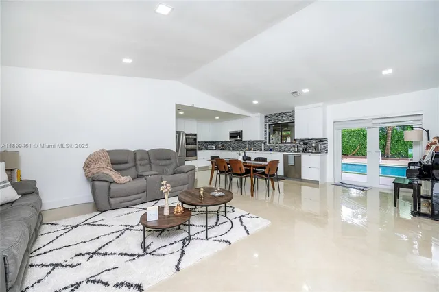 a living room with lots of furniture and kitchen view