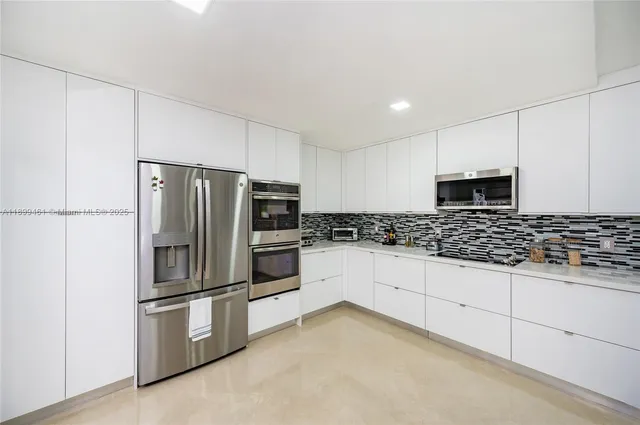 a kitchen with granite countertop a refrigerator and a stove top oven