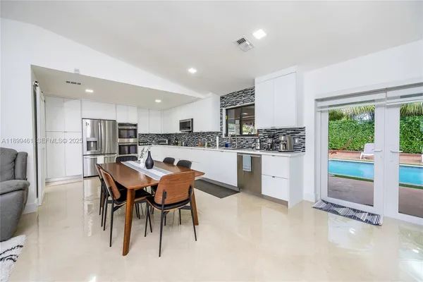 a kitchen with stainless steel appliances kitchen island granite countertop a refrigerator and cabinets
