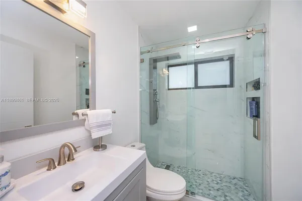 a bathroom with a sink a toilet and shower