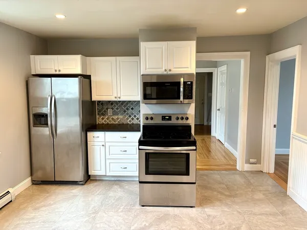 a kitchen with stainless steel appliances granite countertop a stove a refrigerator and a microwave