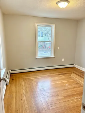 a view of a room with wooden floor and a window