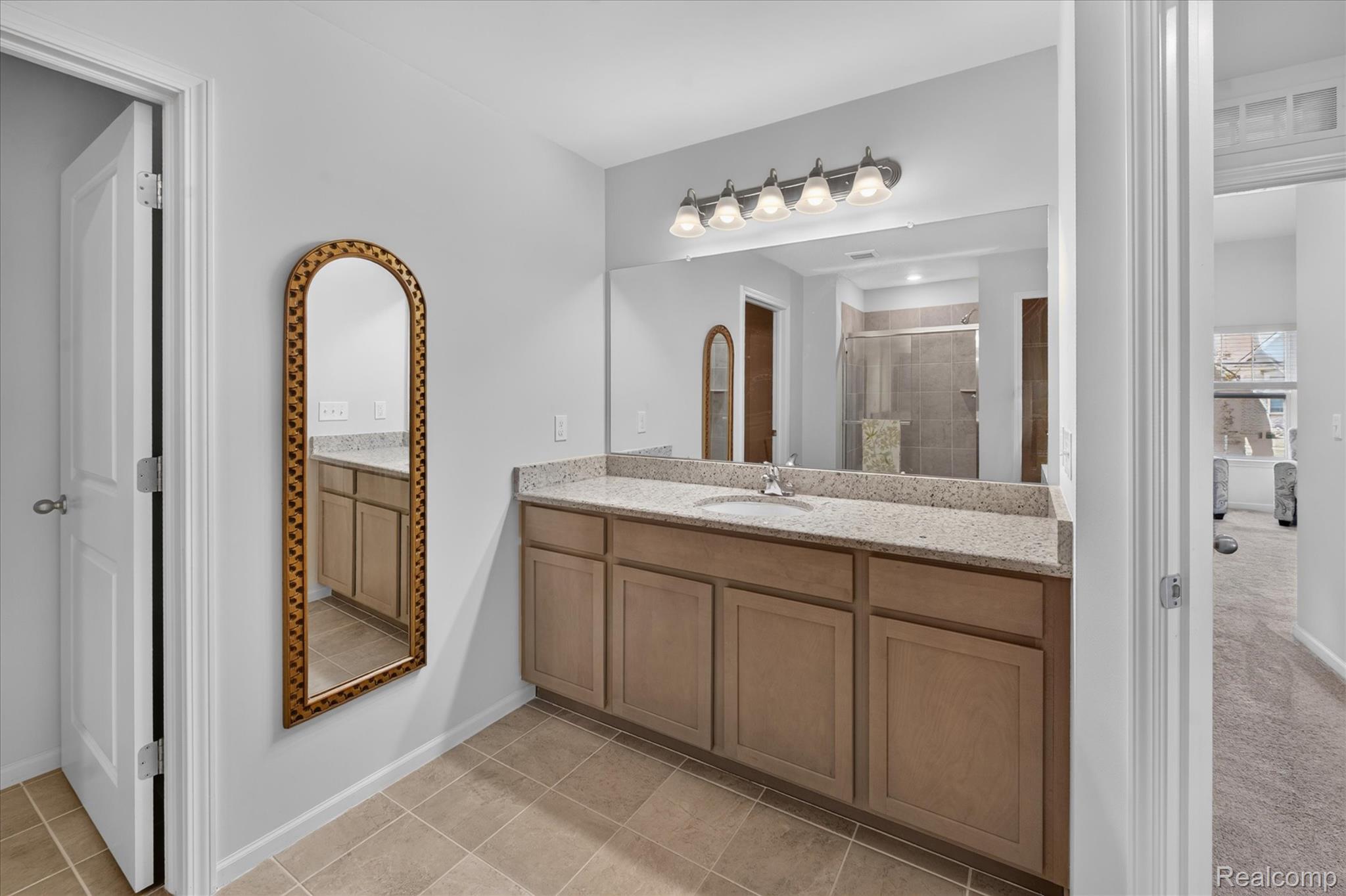 9911 Ridge Run Street Howell, MI 48855 - Photo 18 of 35 Primary vanity area with granite countertop and oversized mirror.