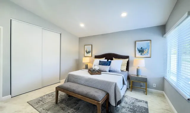 a bedroom with a bed and a potted plant