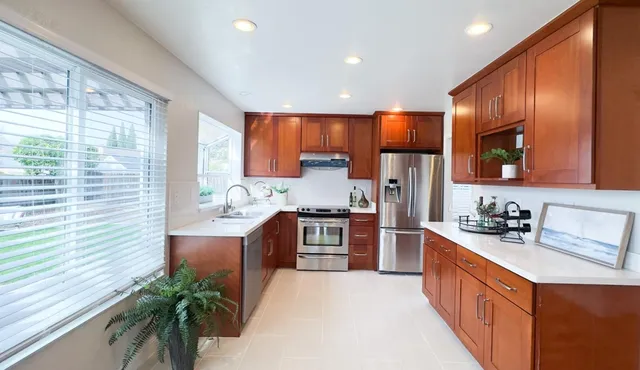 a kitchen with stainless steel appliances granite countertop wooden cabinets a stove top oven a sink and dishwasher