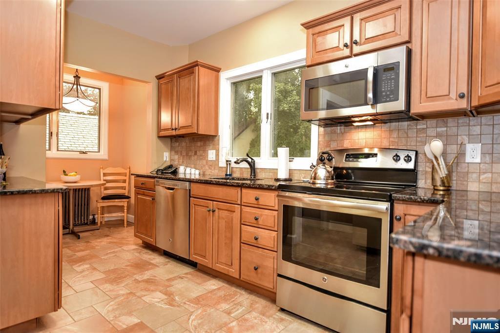255 Pearsall Avenue Ridgewood, NJ 07450 - Photo 14 of 39 a kitchen with stainless steel appliances granite countertop a stove sink microwave and cabinets