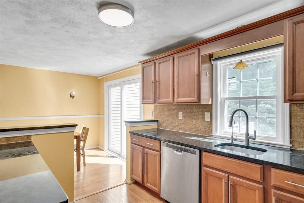 58 MacIntosh Lane, Unit 58 Boxborough, MA 01719 - Photo 6 of 23 a kitchen with stainless steel appliances granite countertop a sink stove and cabinets