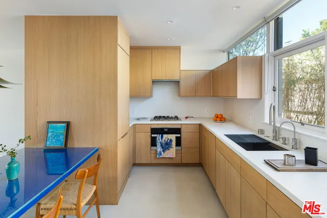 a kitchen with stainless steel appliances granite countertop a sink and a stove next to a window