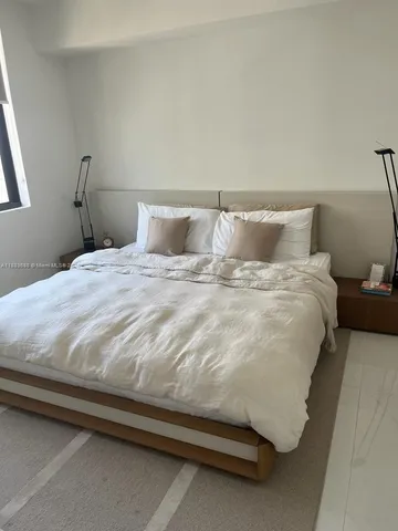a large bed sitting in a bedroom next to a window