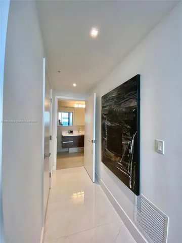 a view of a hallway view with wooden floor and a fireplace