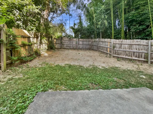 a view of a house with backyard and a trees