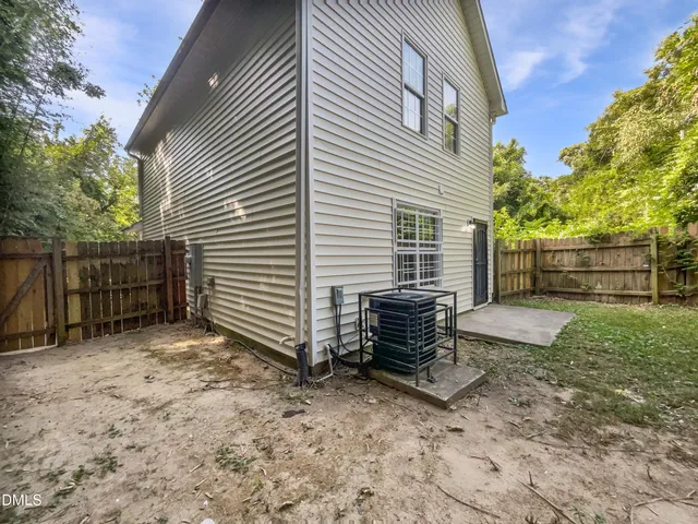 a view of a house with a yard and large tree