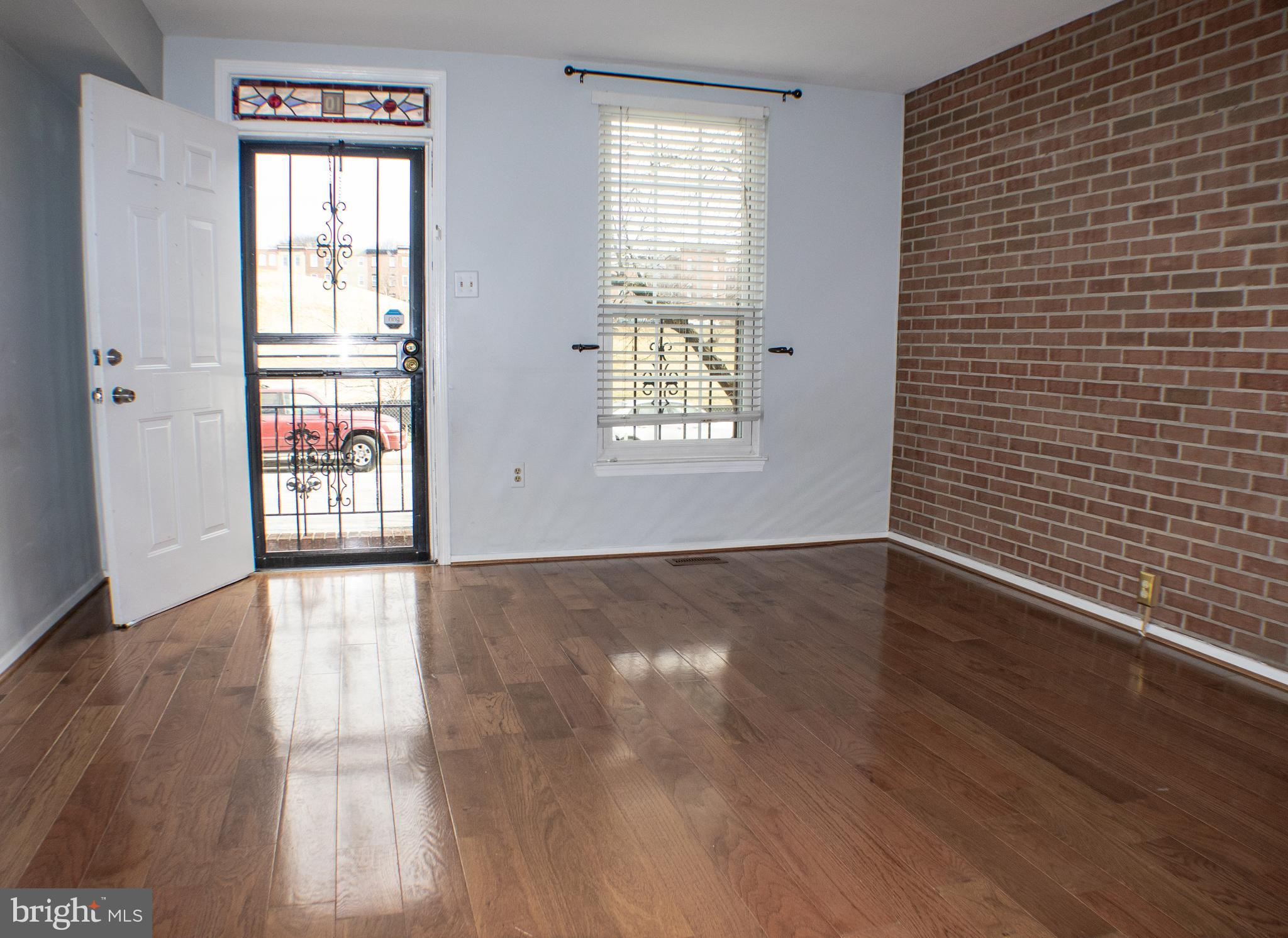7870 Johnnycake Road Windsor Mill, MD 21244 - Photo 1 of 1 a view of an empty room with wooden floor and a window