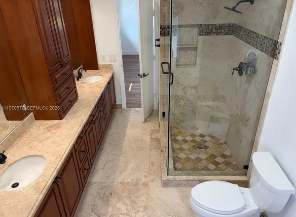 a bathroom with a granite countertop sink toilet and shower