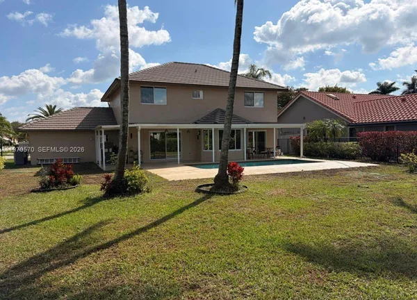 a view of a house with swimming pool and a yard