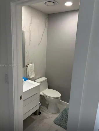 a bathroom with a toilet a sink and a mirror