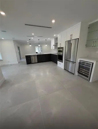a view of kitchen with refrigerator and window