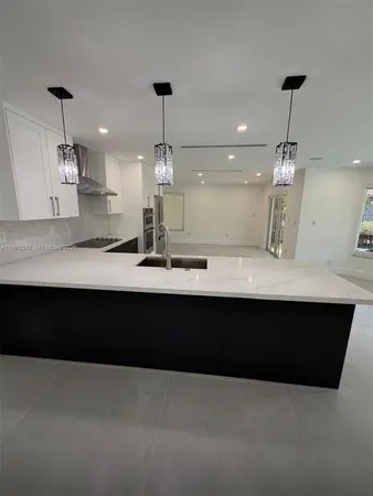 a large kitchen with kitchen island a sink stainless steel appliances and cabinets