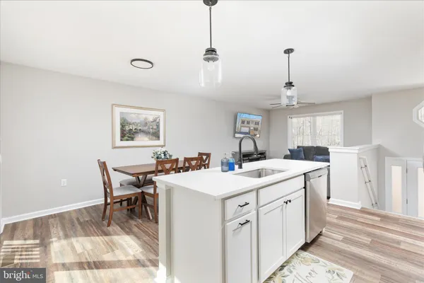 a kitchen that has a sink a stove a table and chairs in it