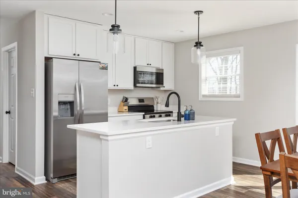 a kitchen with stainless steel appliances granite countertop a sink a stove a refrigerator and island