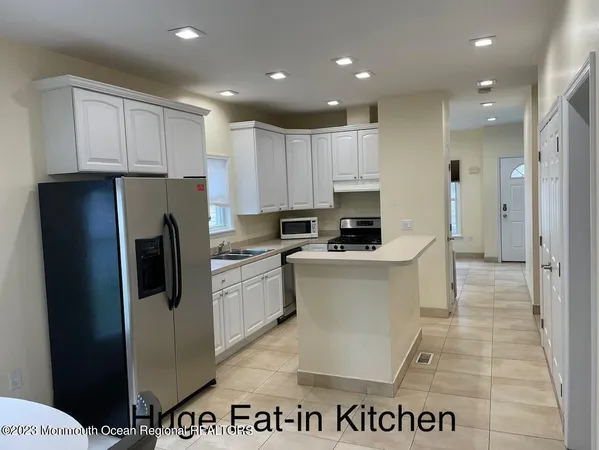 a kitchen with stainless steel appliances granite countertop a refrigerator a stove and a sink