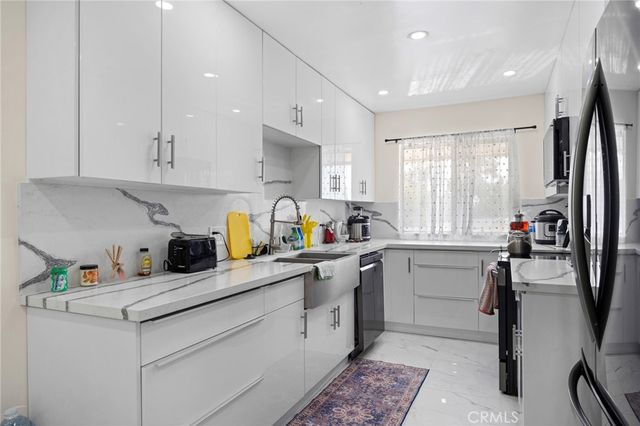 a kitchen with a sink appliances cabinets and furniture