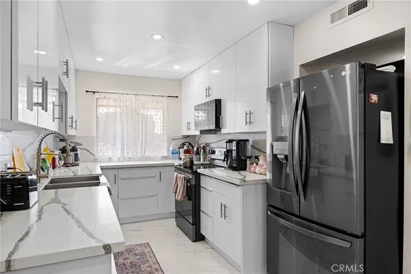 a kitchen with a refrigerator a sink a stove a microwave and cabinets